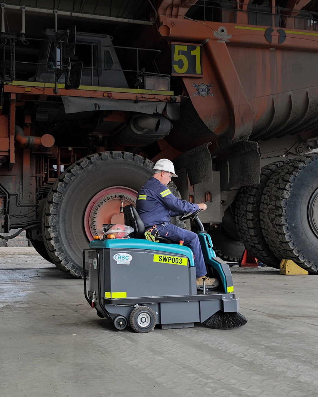 Industrial floor scrubber operating inside airport maintenance hangar