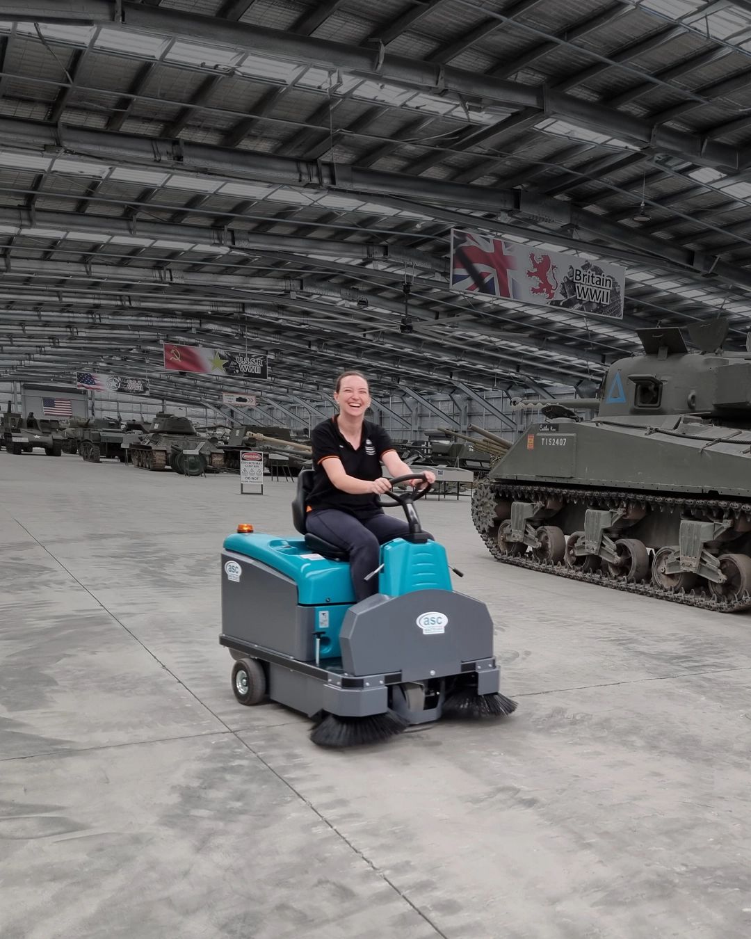 Ride-on industrial sweeper cleaning logistics and distribution centre floor