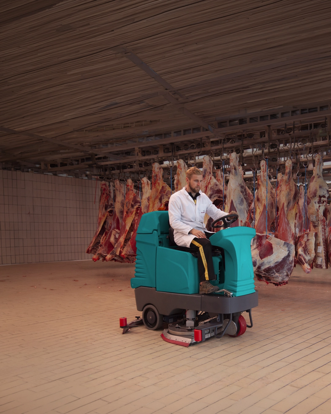 Ride-on floor scrubber cleaning warehouse distribution and cold storage facility